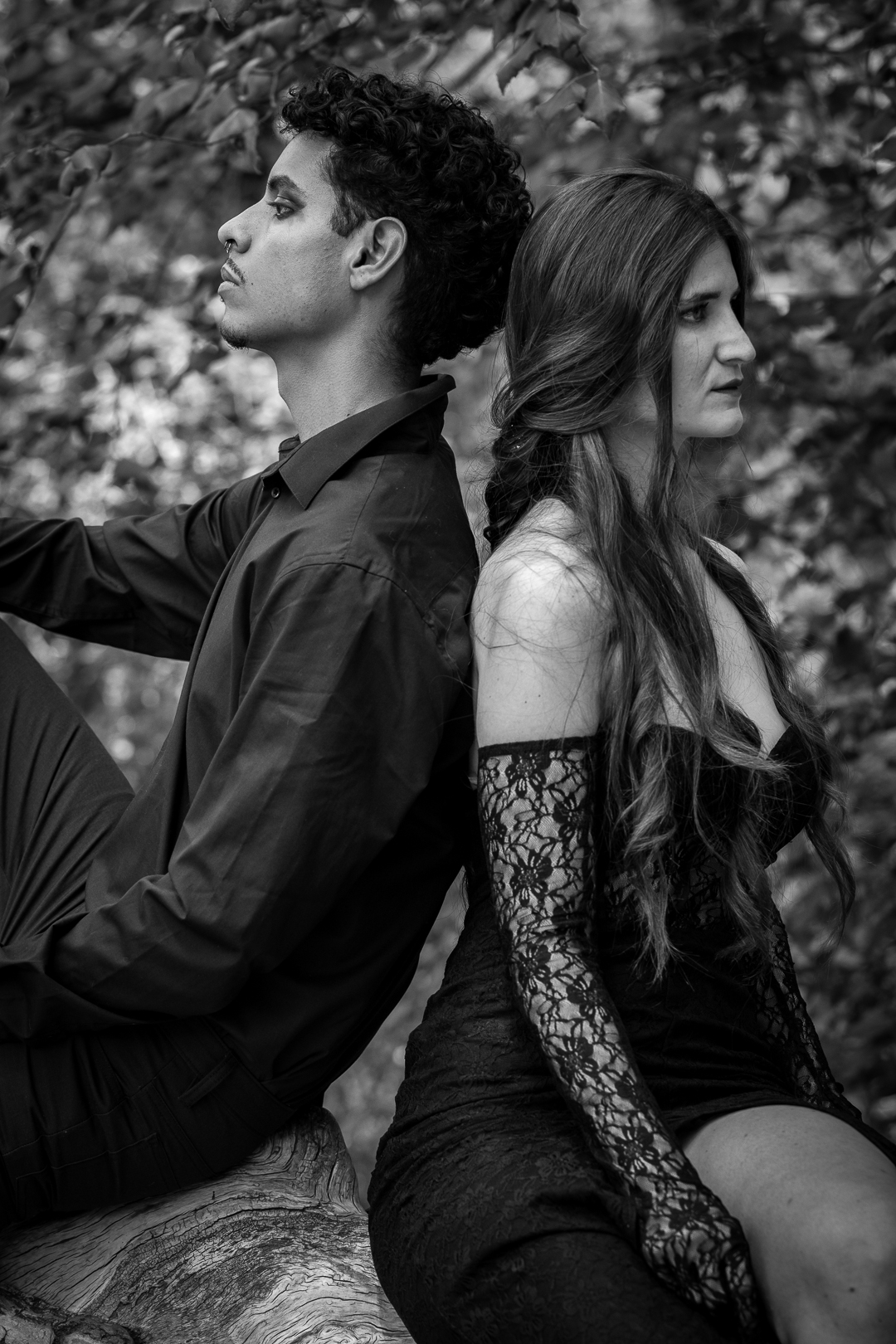 Pareja sentada de espaldas en un entorno natural con estética editorial